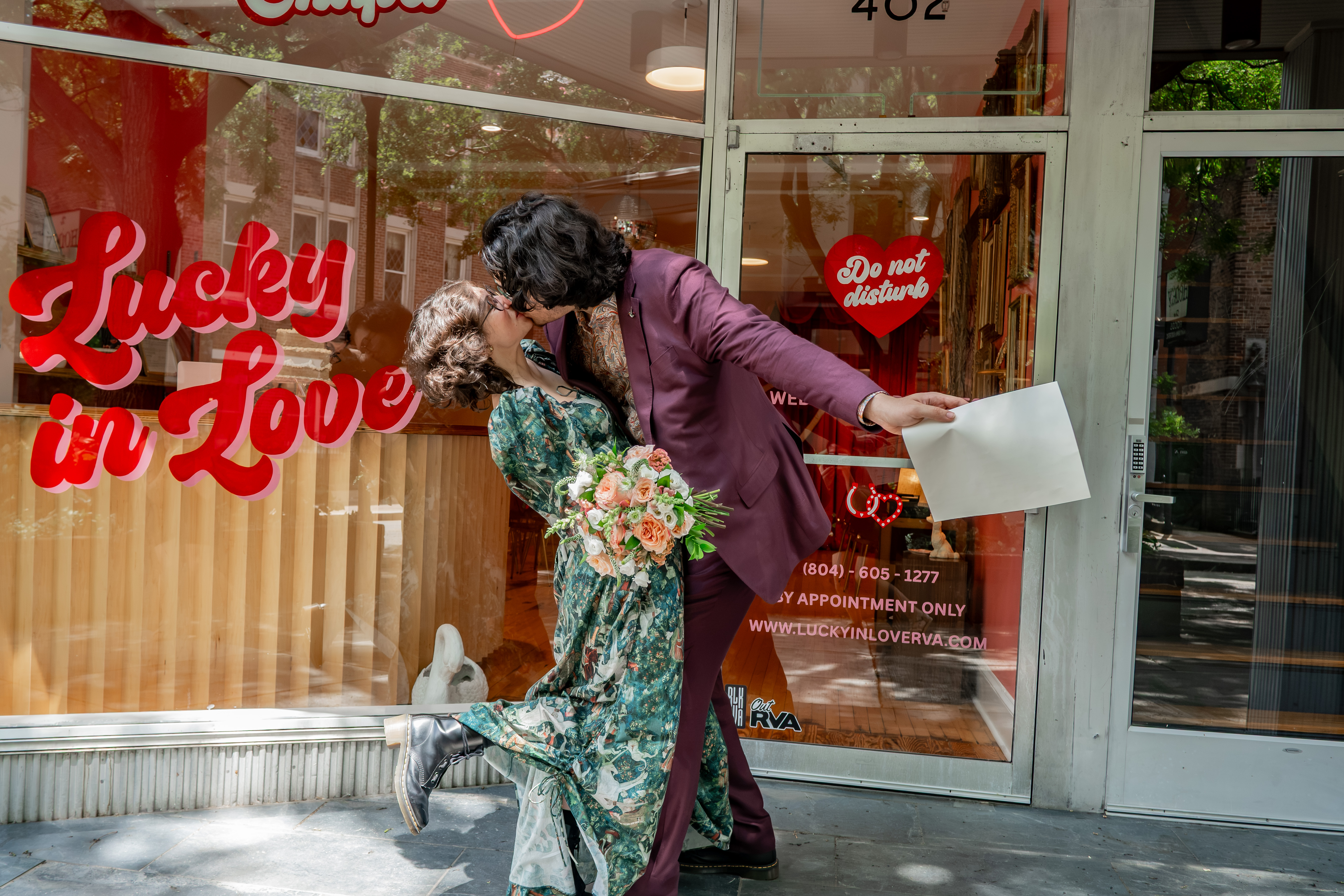 The two of us kissing outside the Lucky in Love storefront, certificate in hand.